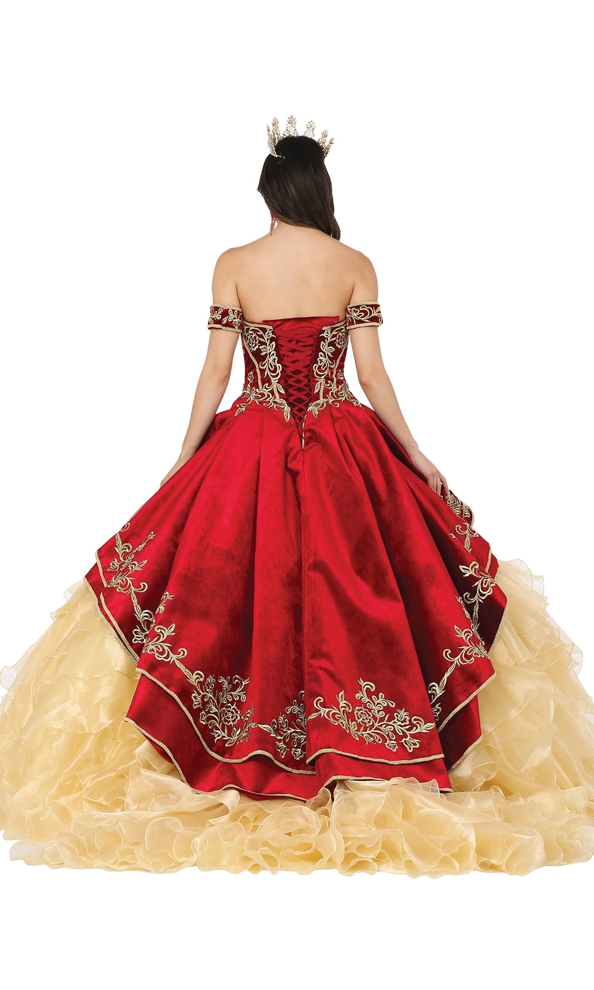 A woman wearing the Quinceanera Dress 1529 by Dancing Queen, a red and gold off-shoulder ball gown with intricate embroidery and a sweetheart strapless neckline, faces away to showcase its luxurious details.